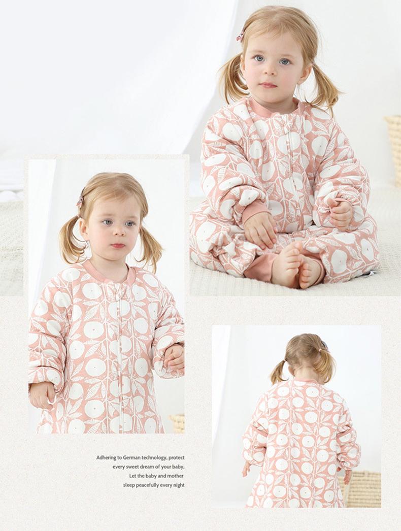 Baby wearing Dear Kora cotton sleeping sack in pink pattern.